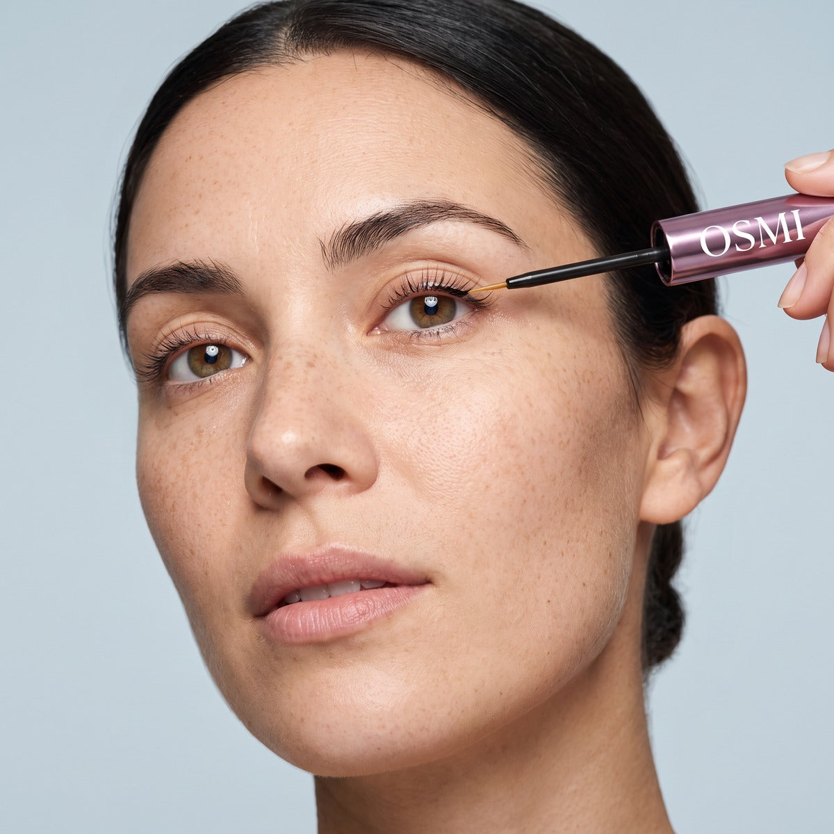 Applying OSMI Lash Serum along the upper lash line